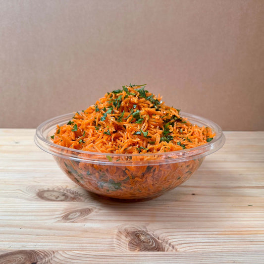 Zesty Carrot Salad with shredded carrots, green chilis, fresh coriander, garlic, and a sweet date syrup, olive oil, and lemon dressing.