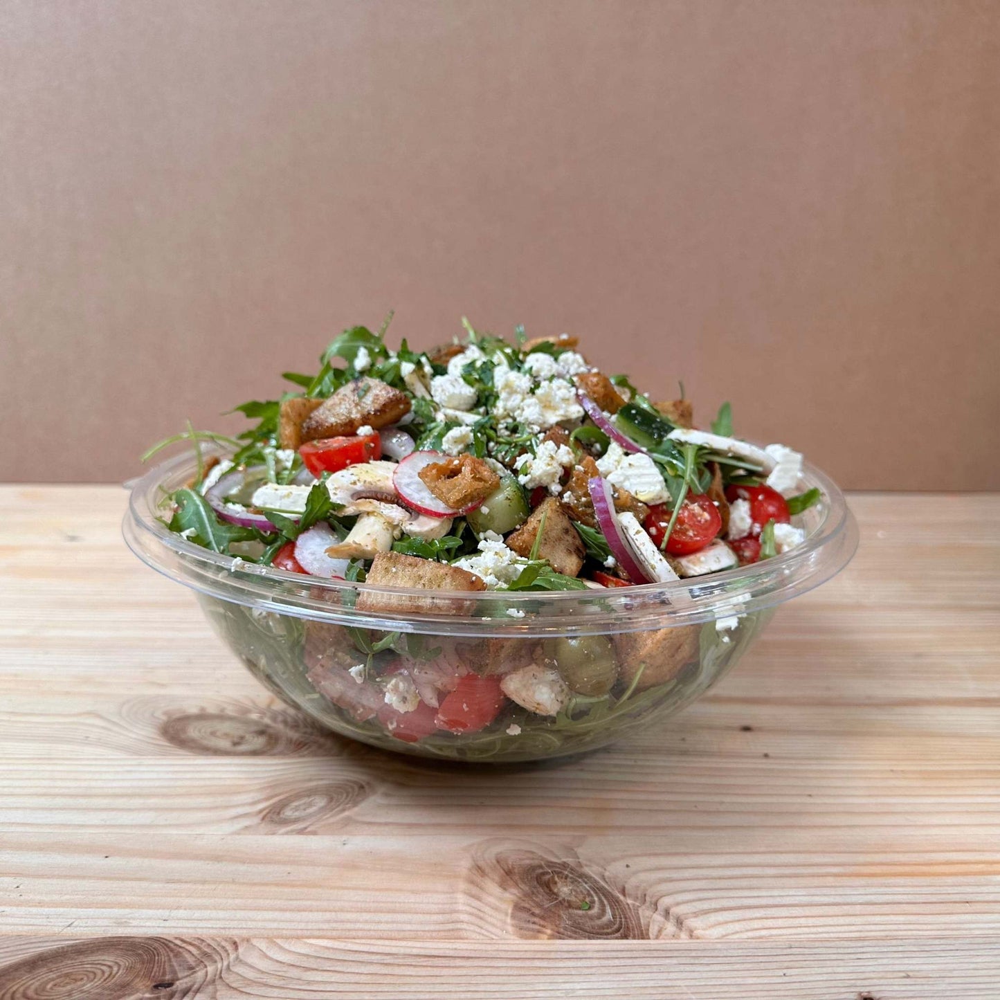 Fresh Garden Salad with lettuce, cucumber, cherry tomatoes, red onion, mushrooms, scallions, radish, olives, and parsley, dressed with sumac, za’atar, and olive oil, topped with Turkish cheese and crispy fried pita bits