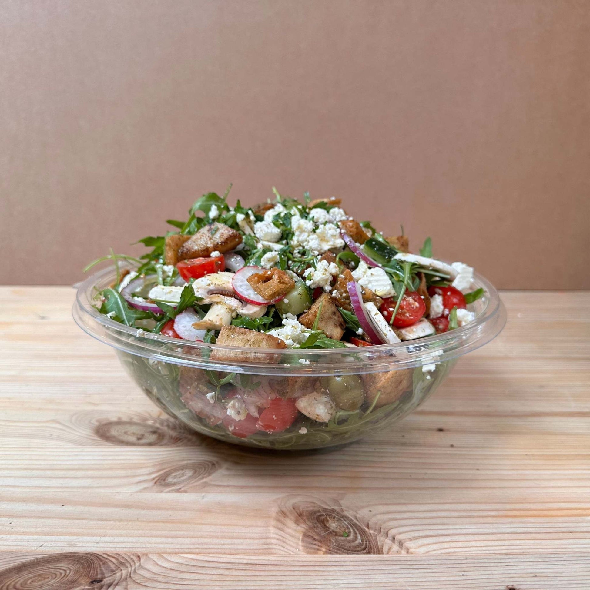 Fresh Garden Salad with lettuce, cucumber, cherry tomatoes, red onion, mushrooms, scallions, radish, olives, and parsley, dressed with sumac, za’atar, and olive oil, topped with Turkish cheese and crispy fried pita bits